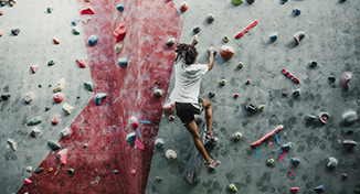 Imagen de  Una persona escalando un muro de escalada.